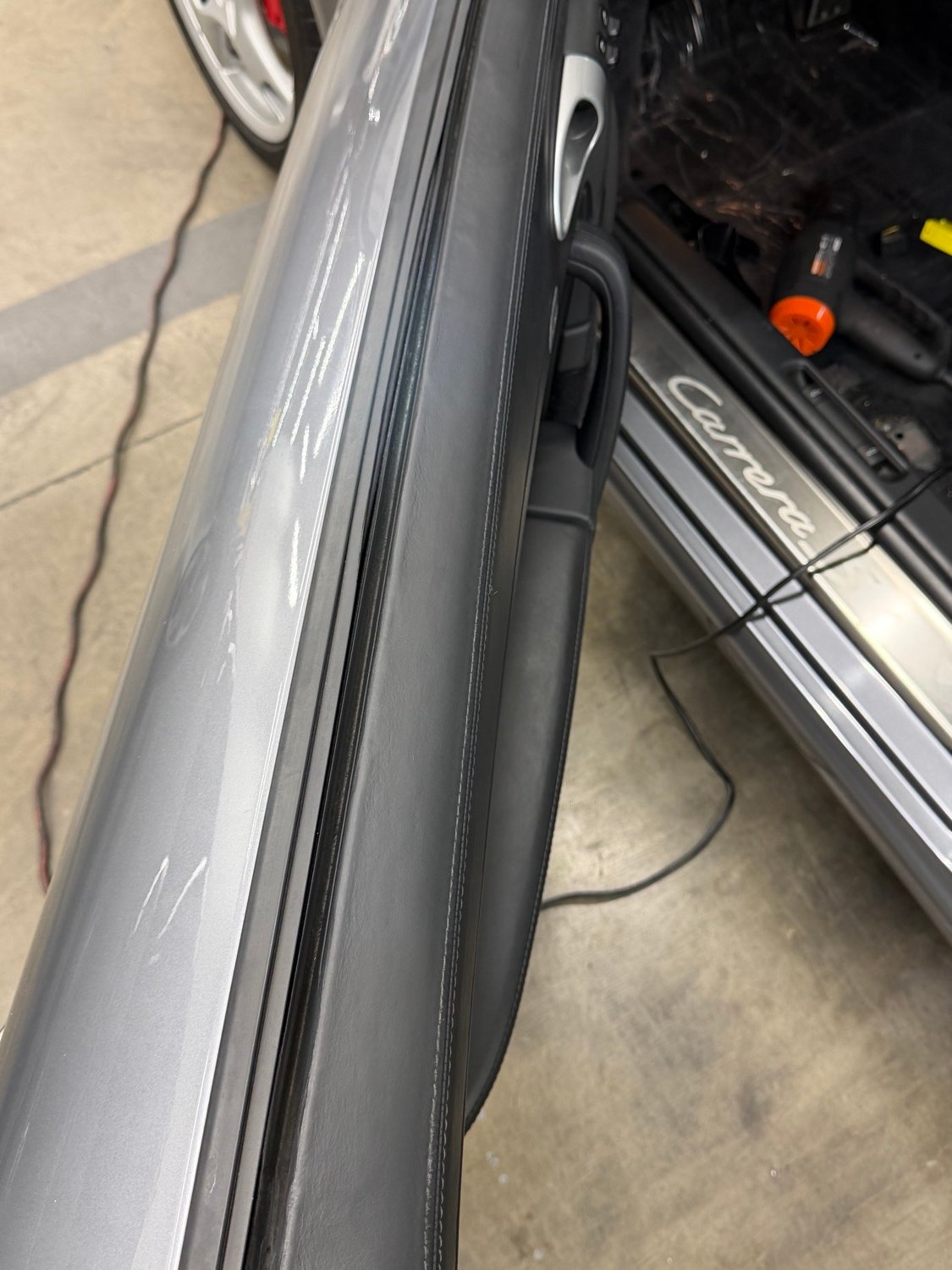 Porsche Carrera door sill and black leather door panel after restoration